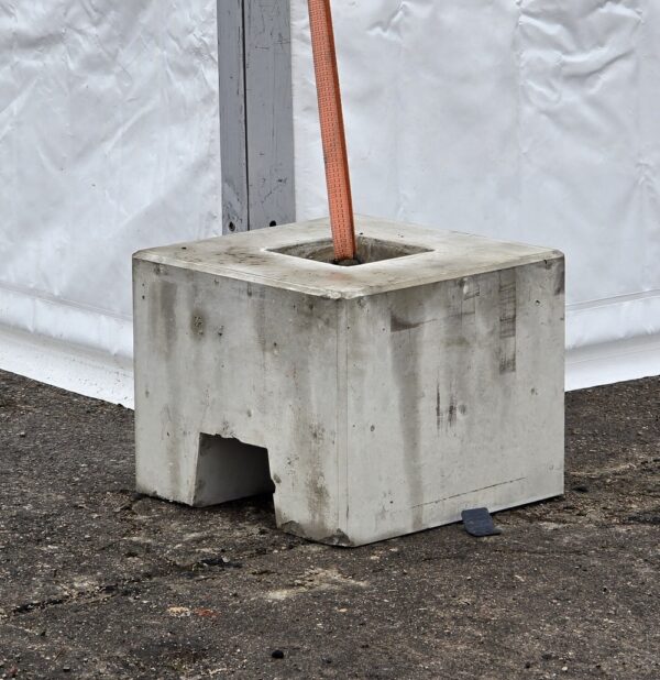 200 kg concrete weight next to a modular tent leg, strap in the anchor point